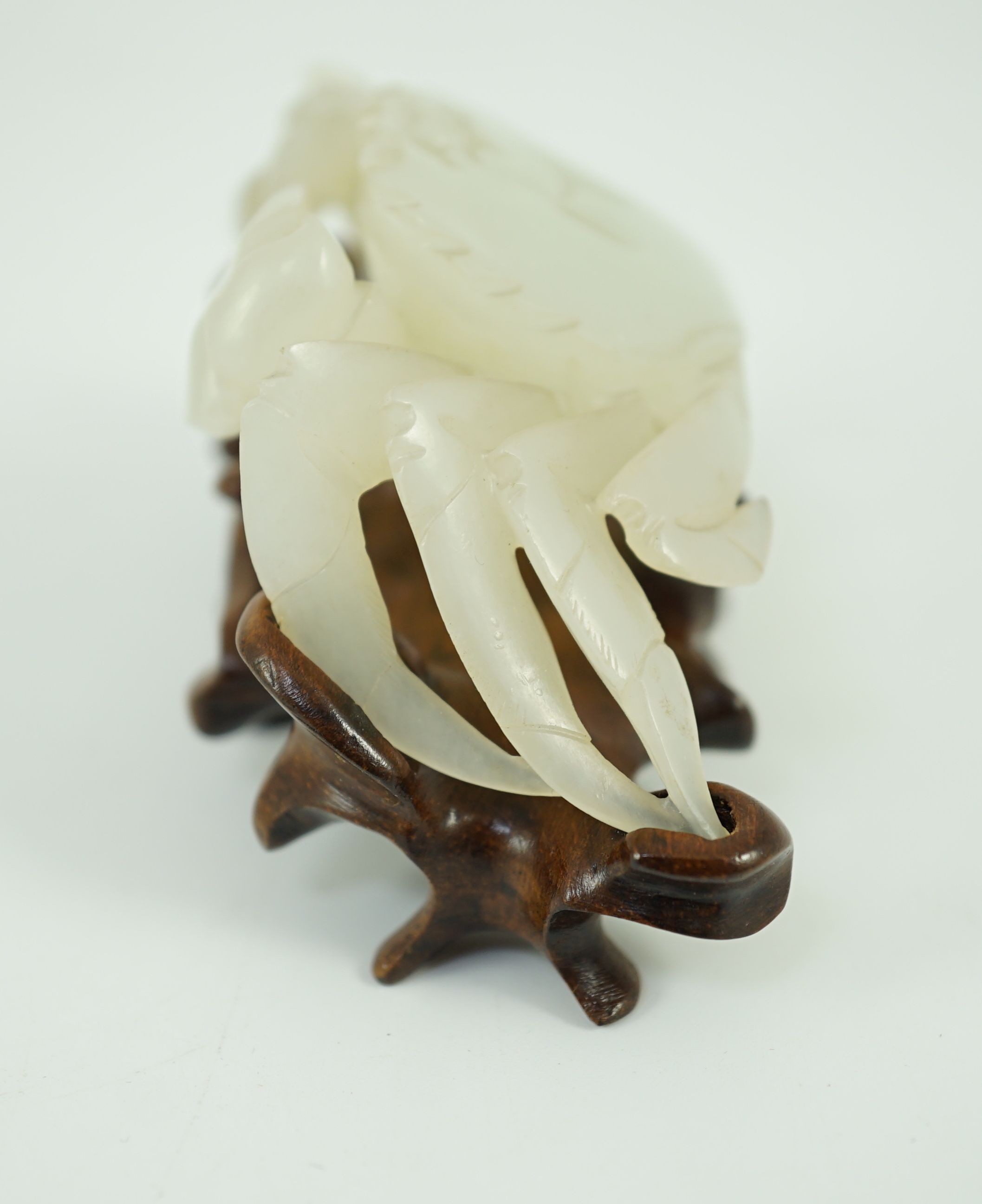 A Chinese pale celadon jade model of a crab, 20th century, 8.4 cm wide, wood stand